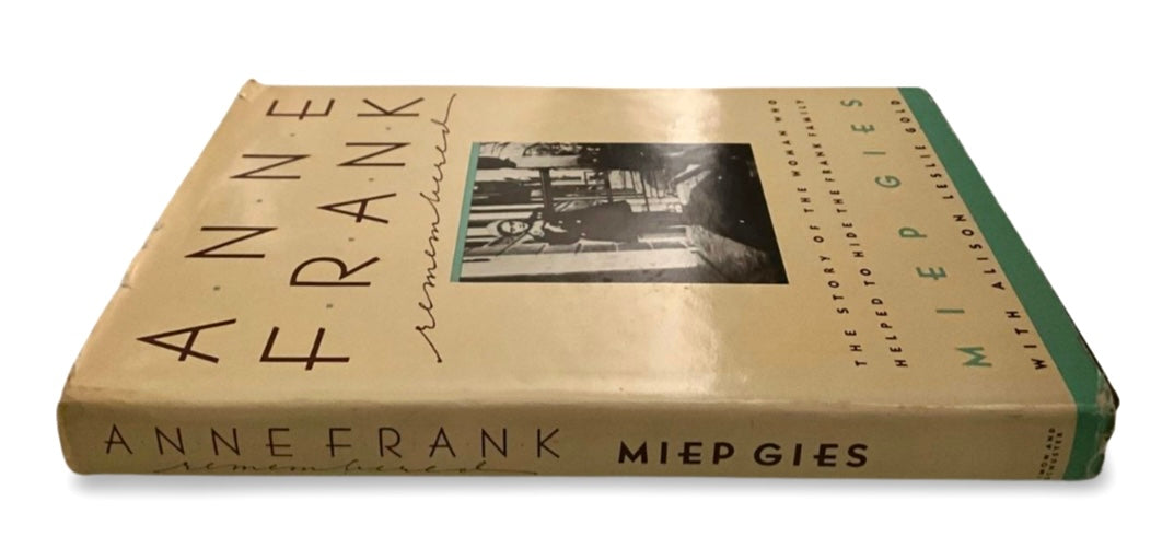 Book titled 'Anne Frank' with a black and white photo of Anne in front of a building on the cover
