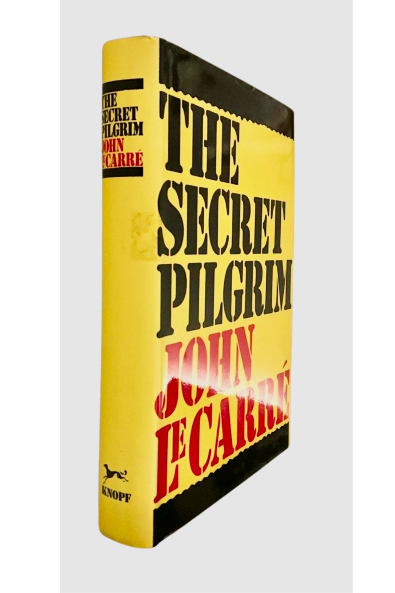 Book titled 'The Secret Pilgrim' by John le Carré with a yellow and black cover.
