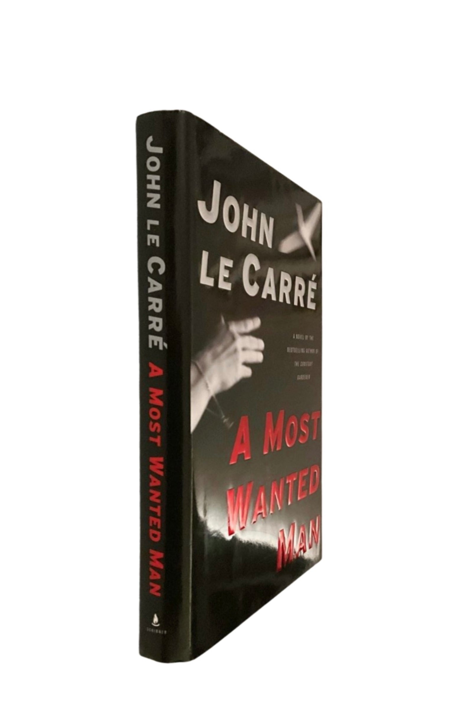 Book titled 'A Most Wanted Man' by John Le Carre with a black cover and red text.