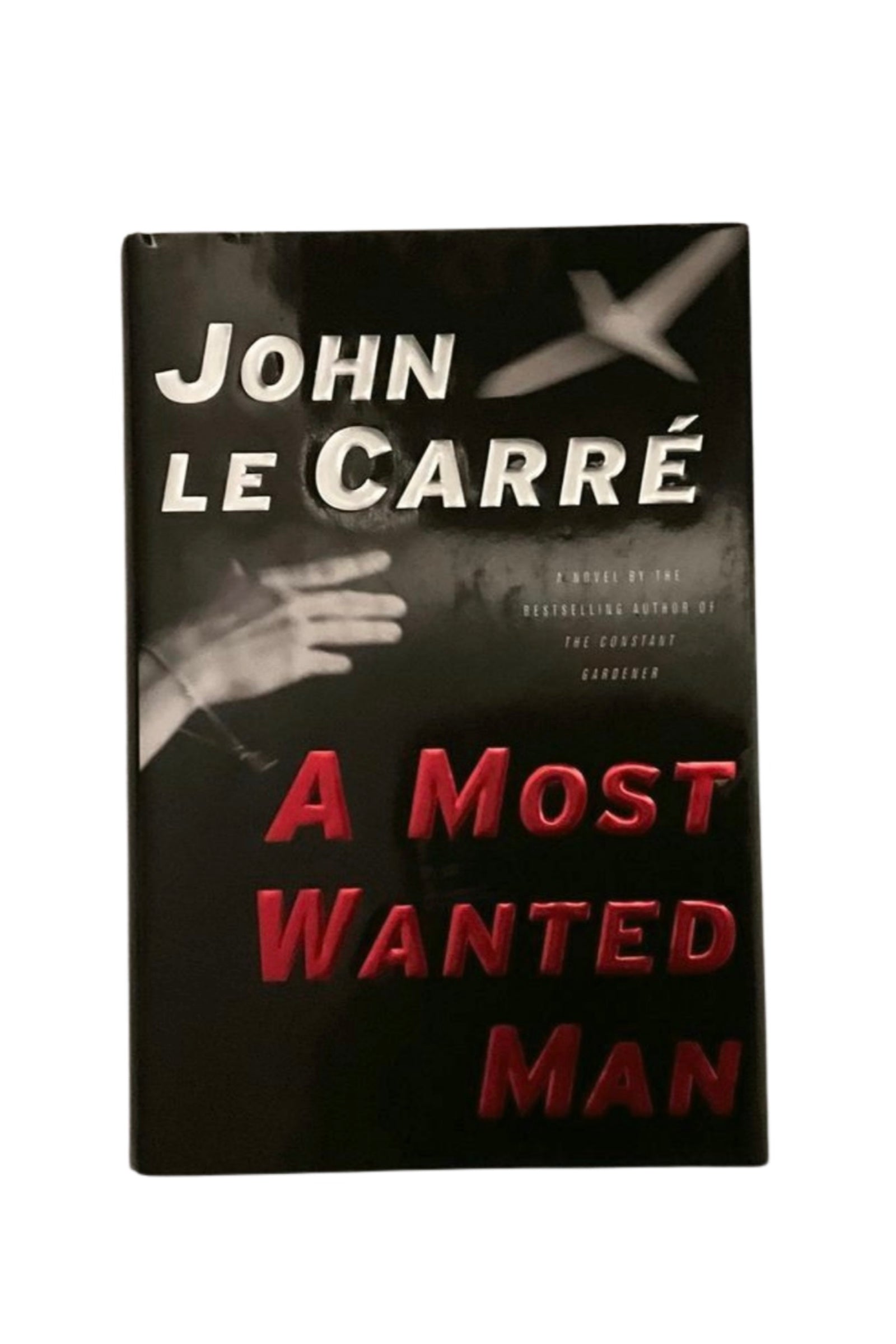 Book cover of 'A Most Wanted Man' by John Le Carre with a black background and red text.