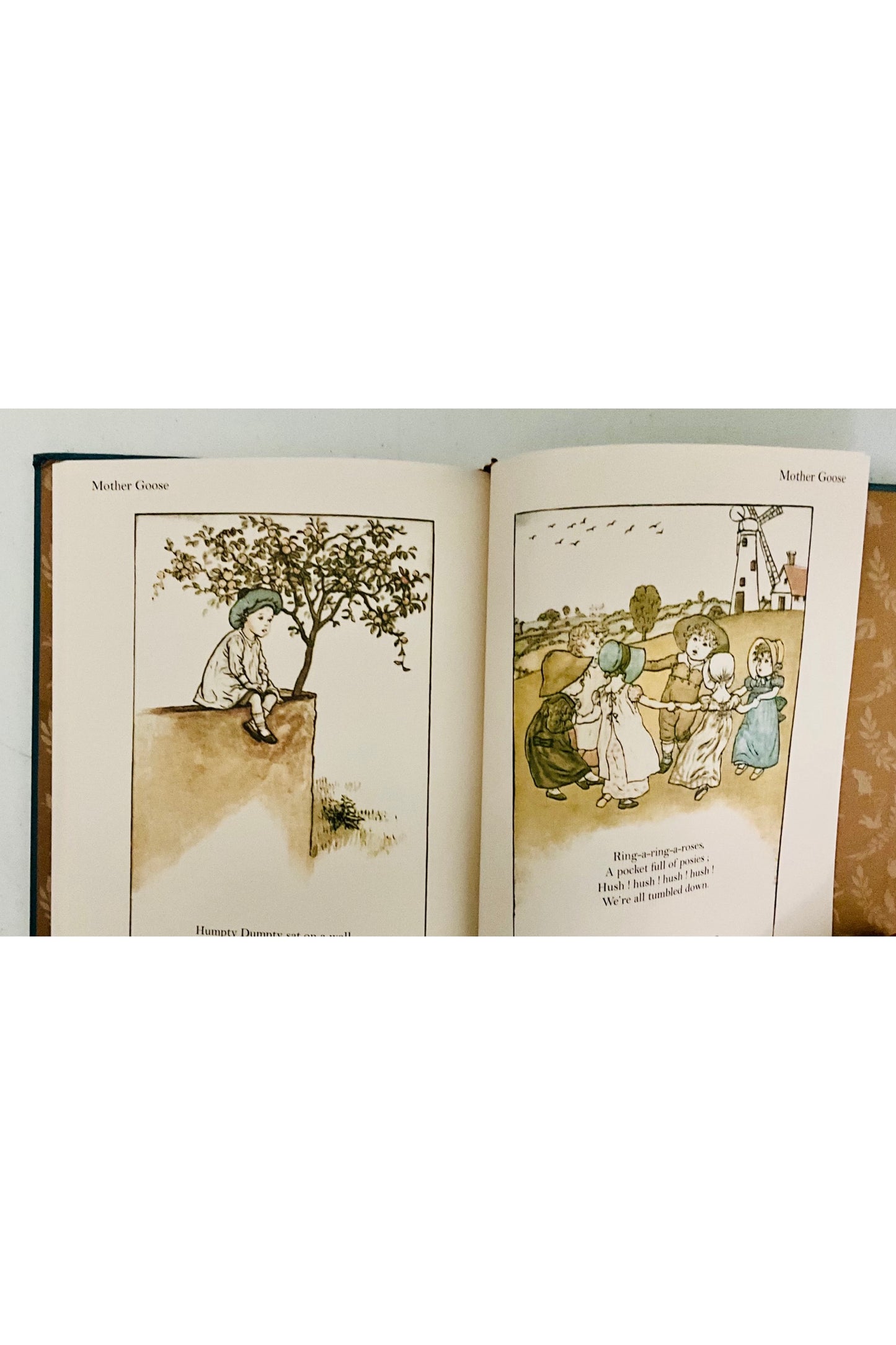 Open book with illustrations of children and an apple tree on a white background