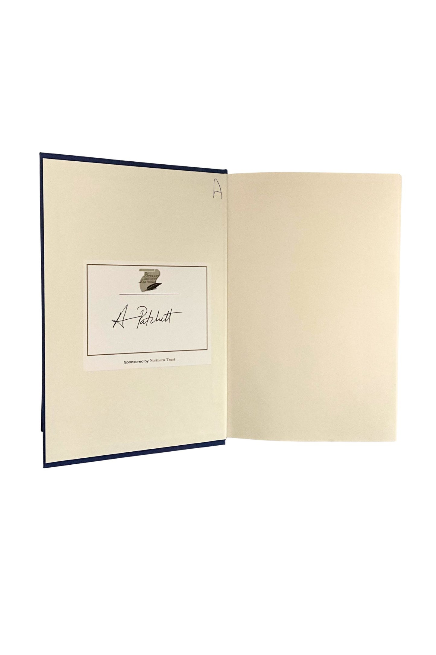 Book opened to the inside front cover showing the author’s signature on a bookplate