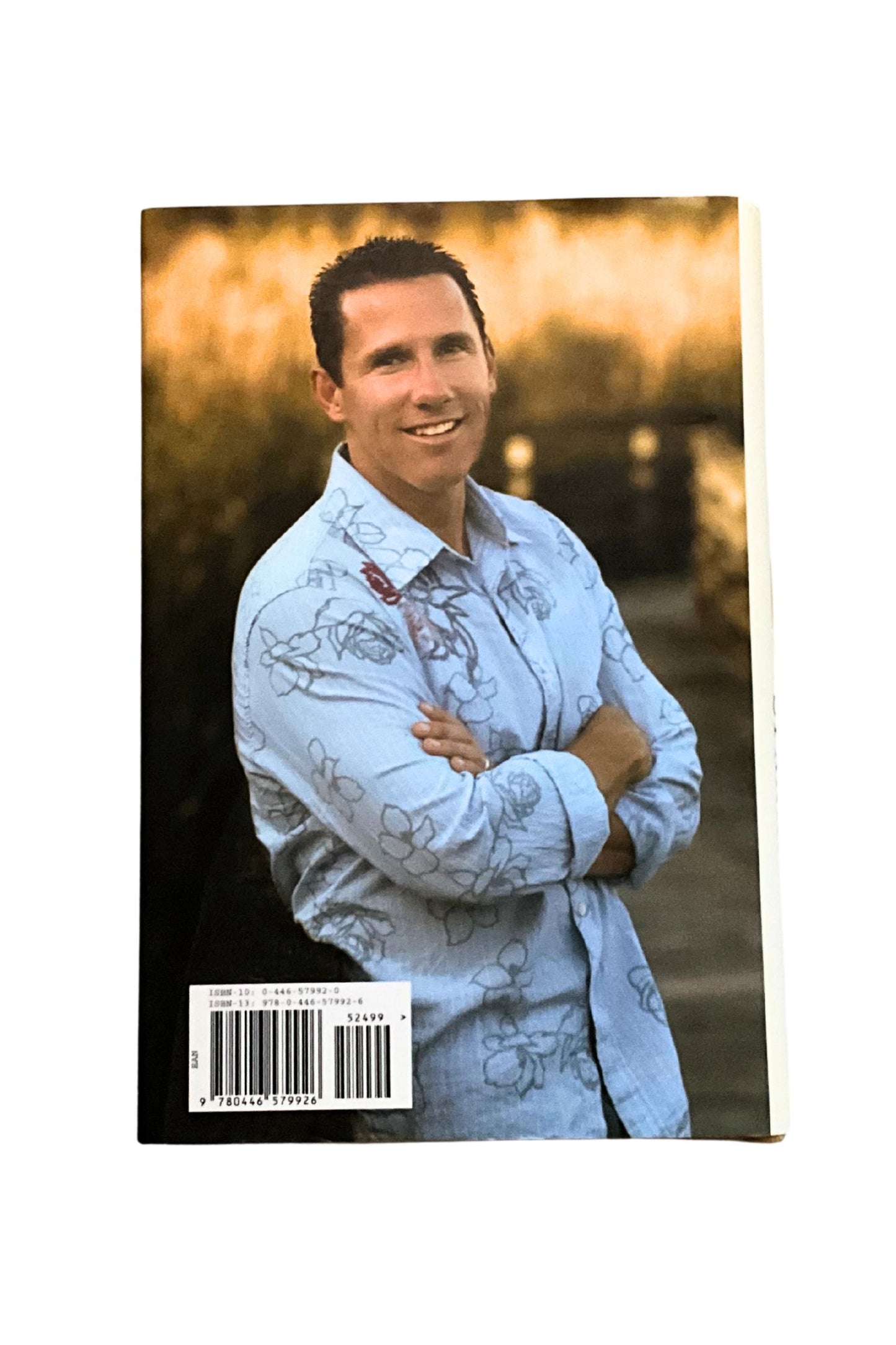 Back cover of ‘The Choice’ showing the author wearing a light blue shirt with floral patterns against a blurred outdoor background
