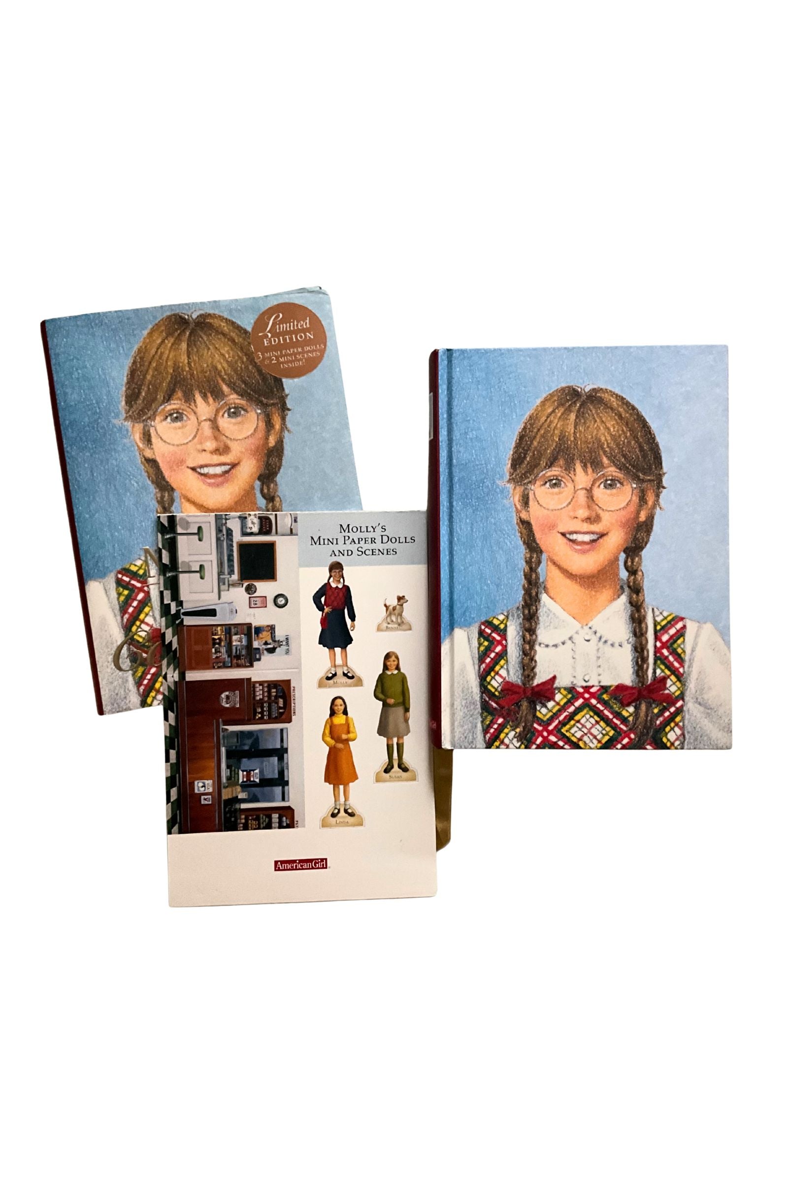 A book and  its cover decorated with the same image of a young girl with glasses and braided hair, set against a white background. It also shows 3 mini paper dolls and mini dollhouse.