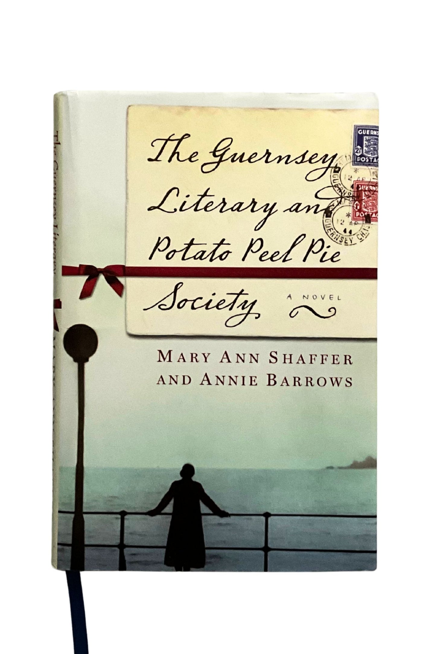 Book cover of 'The Guernsey Literary and Potato Peel Pie Society' with a silhouette of a woman by the sea.