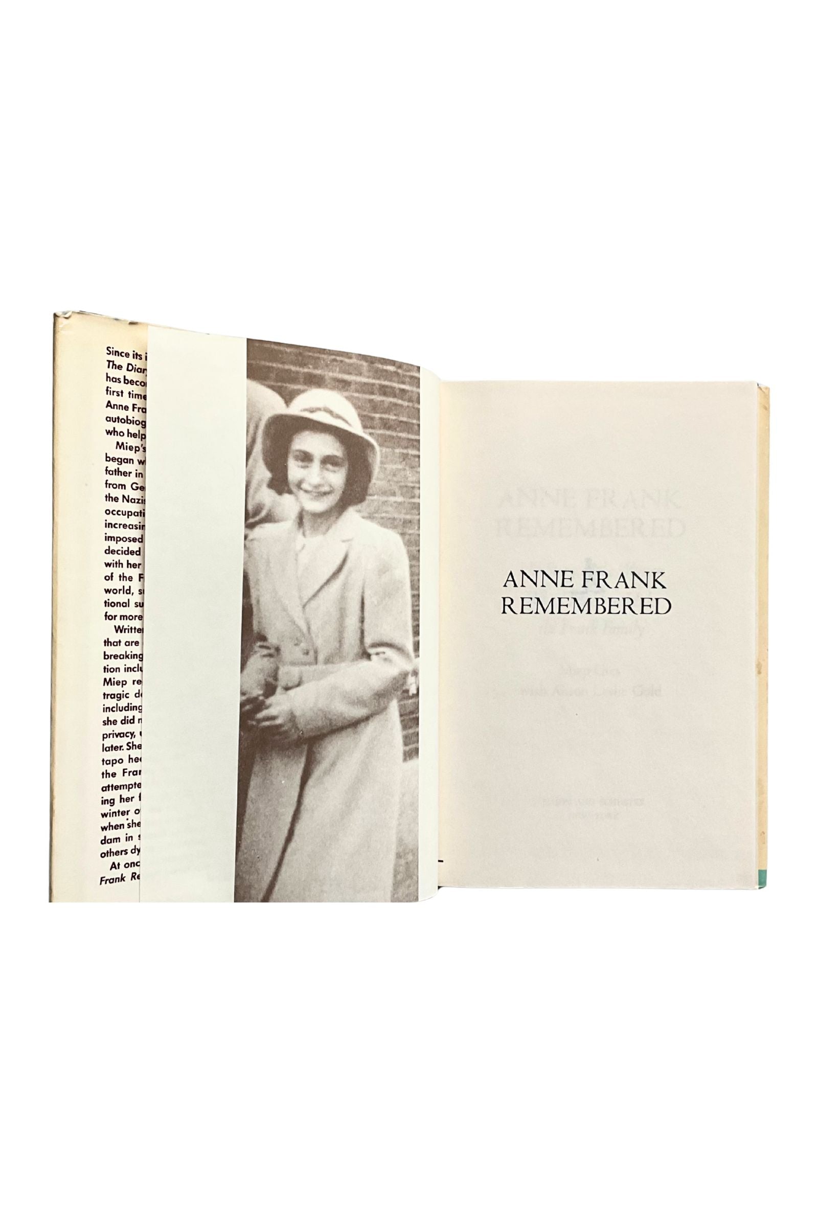Book open to a page with a black and white photo of Anne Frank wearing a hat and coat, and the text 'Anne Frank Remembered'.